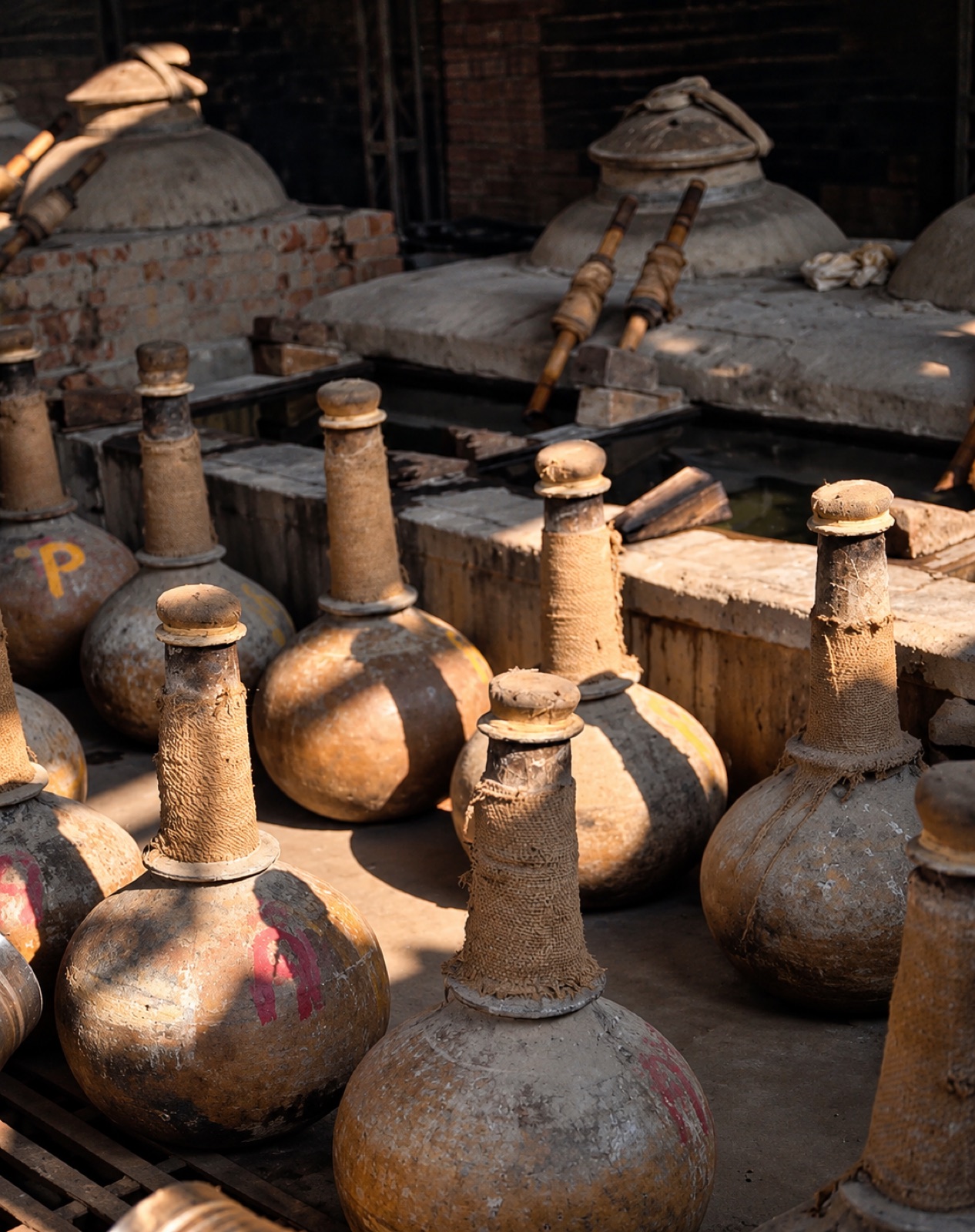 Sunlit earthenware and distillation vessels in a Kannauj attar workshop
